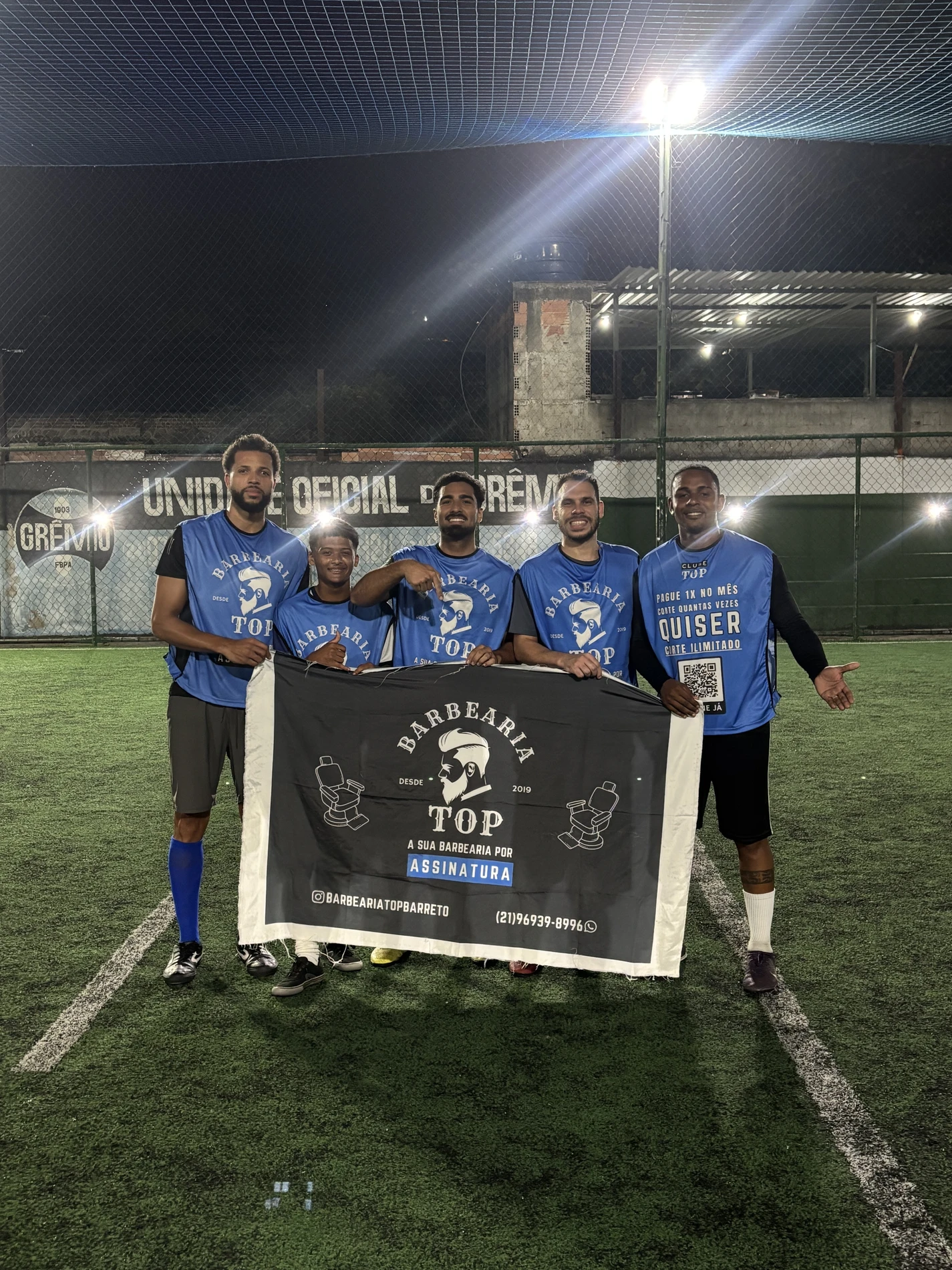 Time segurando a bandeira oficial da Barbearia TOP